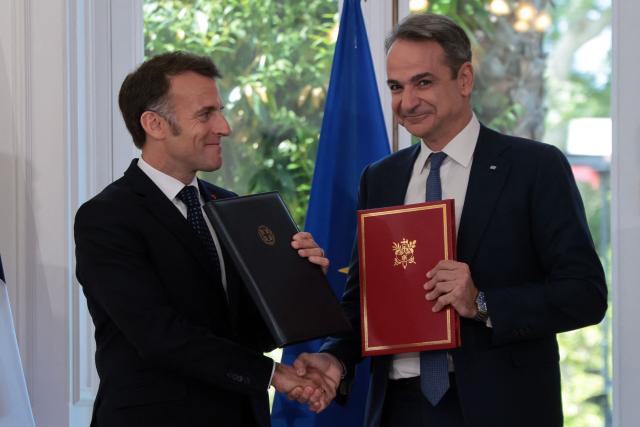 France's President Emmanuel Macron and Greece's Prime Minister Kyriakos Mitsotakis shake hands after signing bilateral agreements at Maximos mansion, in Athens, on April 25, 2026. The two leaders signed a text titled “Enhanced Comprehensive Strategic Partnership between Greece and France” and signed the renewal of the Strategic Relationship Agreement for cooperation in security and defense. (Photo by Ludovic MARIN / AFP)