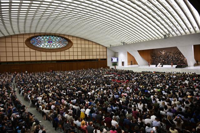 Participants in the National Meeting of Catholic Religion Teachers, who teach religion courses in Italian public schools, promoted by the CEI (Catholic Episcopal Conference), attend a private audience with Pope Leo XIV (Rear R on stage) at Paul VI Hall in the Vatican on April 25, 2026. (Photo by Andreas SOLARO / AFP)