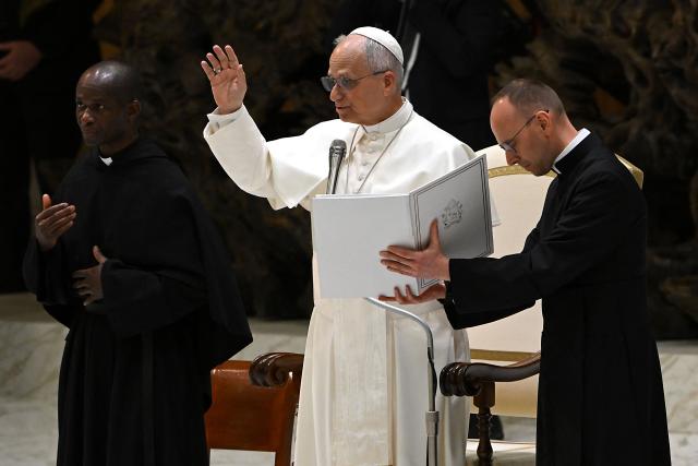 Pope Leo XIV blesses the faithful during a private audience with participants in the National Meeting of Catholic Religion Teachers, who teach religion courses in Italian public schools, promoted by the CEI (Catholic Episcopal Conference), at Paul VI Hall in the Vatican on April 25, 2026. (Photo by Andreas SOLARO / AFP)