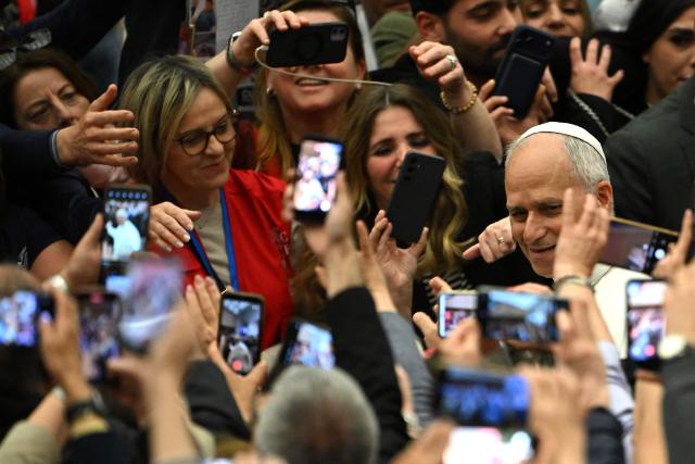 Pope Leo XIV (R) meets with participants during a private audience with participants in the National Meeting of Catholic Religion Teachers, who teach religion courses in Italian public schools, promoted by the CEI (Catholic Episcopal Conference), at Paul VI Hall in the Vatican on April 25, 2026. (Photo by Andreas SOLARO / AFP)