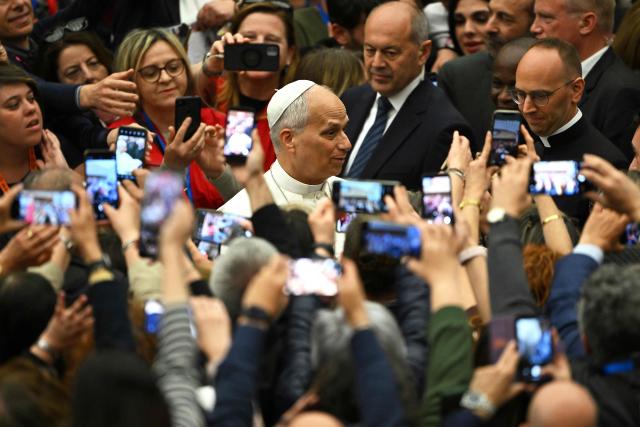 Pope Leo XIV (R) meets with participants during a private audience with participants in the National Meeting of Catholic Religion Teachers, who teach religion courses in Italian public schools, promoted by the CEI (Catholic Episcopal Conference), at Paul VI Hall in the Vatican on April 25, 2026. (Photo by Andreas SOLARO / AFP)
