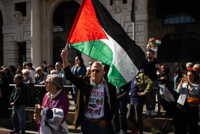 A man holds a Palestinian flag during a march marking the 81st Liberation Day which commemorates the end of the Nazi-Fascist occupation in Italy during World War II in Genoa on April 25, 2026. (Photo by MARCO BERTORELLO / AFP)