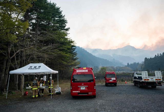 Firefighters use a tent as a command centre to coordinate teams fighting the fire in Kirikiri in Iwate Prefecture on April 25, 2026. Hundreds of firefighters were battling wildfires in the forests of northern Japan on April 25, as authorities urged more than 3,200 people to evacuate from their homes, government officials said. (Photo by ANDREW CABALLERO-REYNOLDS / AFP)
