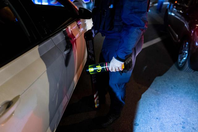 French National Police officer holds a nitrous oxide canister found inside a car during a roadside night check in Lille, northern France, on April 25, 2026. (Photo by Sameer Al-DOUMY / AFP)