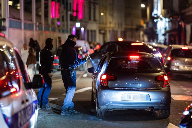 French National Police officers stop a car during a roadside night check for nitrous oxide canisters in Lille, northern France, on April 25, 2026. (Photo by Sameer Al-DOUMY / AFP)