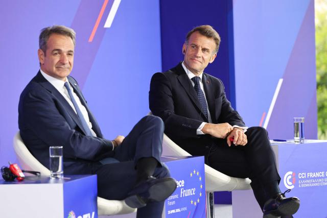 Greece's Prime Minister Kyriakos Mitsotakis (L) and France's President Emmanuel Macron attend a Franco-Greek Economic Forum at the Stavros Niarchos foundation in Athens, on April 25, 2026. The two leaders signed a text titled “Enhanced Comprehensive Strategic Partnership between Greece and France” and signed the renewal of the Strategic Relationship Agreement for cooperation in security and defense. (Photo by Ludovic MARIN / AFP)