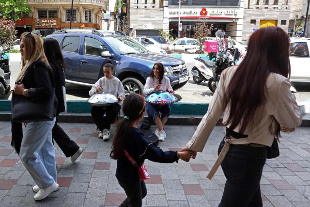 Iranian street musicians perform along a street in Tehran on April 25, 2026. (Photo by AFP) / 