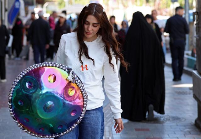 Iranian street musician Sadaf arrives to perform in a street, in Tehran on April 25, 2026. (Photo by AFP) / 