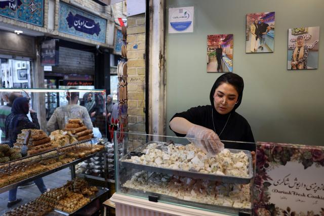 An Iranian woman works in a sweet shop, in Tehran on April 25, 2026. (Photo by AFP) / 