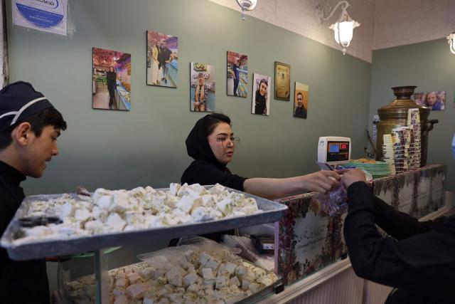 An Iranian woman works in a sweet shop, in Tehran on April 25, 2026. (Photo by AFP) / 
