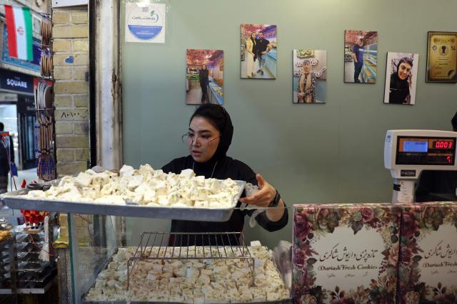 An Iranian woman works in a sweet shop, in Tehran on April 25, 2026. (Photo by AFP) / 