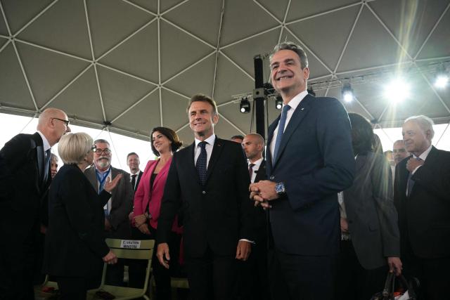 Greece's Prime Minister Kyriakos Mitsotakis (C-R) and France's President Emmanuel Macron (C-L) arrive to attend a Franco-Greek Economic Forum at the Stavros Niarchos foundation in Athens, on April 25, 2026. The two leaders signed a text titled “Enhanced Comprehensive Strategic Partnership between Greece and France” and signed the renewal of the Strategic Relationship Agreement for cooperation in security and defense. (Photo by Angelos Tzortzinis / AFP)