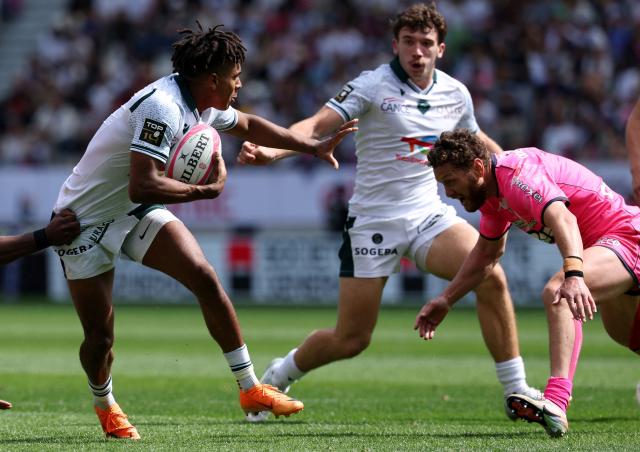 CORRECTION / Theo Pau's French wing Thйo Attissogbe (L) runs with a ball during the French Top 14 rugby union match between Stade Francais and  Section Paloise (Pau) at the Jean Bouin stadium in Paris, on April 25, 2026. (Photo by FRANCK FIFE / AFP) / “The erroneous mention[s] appearing in the metadata of this photo by FRANCK FIFE has been modified in AFP systems in the following manner: [Theo Attissogbe] instead of [Aaron Grandidier-Nkanang]. Please immediately remove the erroneous mention[s] from all your online services and delete it (them) from your servers. If you have been authorized by AFP to distribute it (them) to third parties, please ensure that the same actions are carried out by them. Failure to promptly comply with these instructions will entail liability on your part for any continued or post notification usage. Therefore we thank you very much for all your attention and prompt action. We are sorry for the inconvenience this notification may cause and remain at your disposal for any further information you may require.”