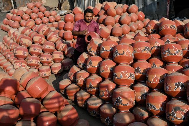 A man sorts earthen pots used to store water during summer on the outskirts of Ahmedabad on April 25, 2026. (Photo by Shammi MEHRA / AFP)