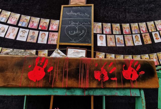 Images of children killed on the first day of the war in an alleged US-Israeli missile strike on a school in the southern Iranian city of Minab are strung along the wall of a mosque in the capital Tehran on April 25, 2026. On February 28, Israel and the United States launched strikes on Iran, killing its supreme leader and triggering a war that spread across the Middle East. (Photo by ATTA KENARE / AFP) / 