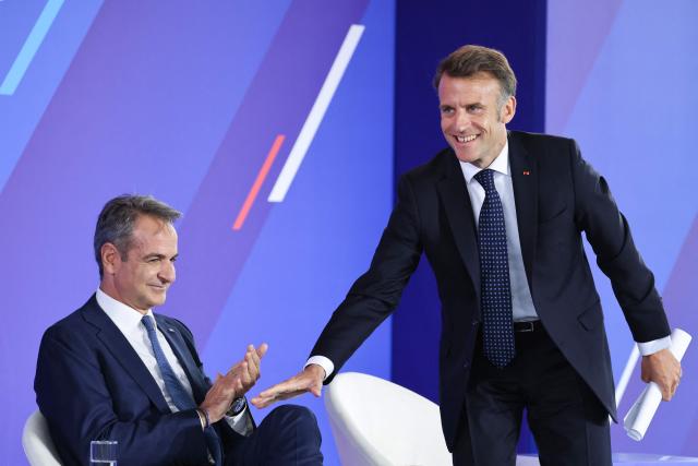 Greece's Prime Minister Kyriakos Mitsotakis (L) and France's President Emmanuel Macron attend a Franco-Greek Economic Forum at the Stavros Niarchos foundation in Athens, on April 25, 2026. The two leaders signed a text titled “Enhanced Comprehensive Strategic Partnership between Greece and France” and signed the renewal of the Strategic Relationship Agreement for cooperation in security and defense. (Photo by Ludovic MARIN / AFP)