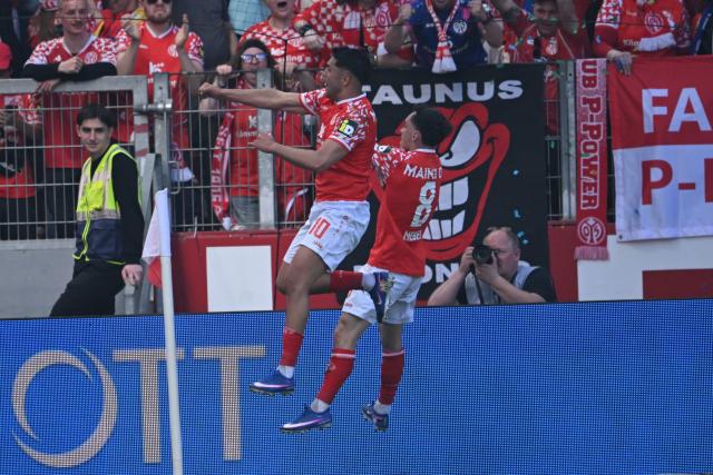 Mainz' German midfielder #08 Paul Nebel celebrates with Mainz' German midfielder #10 Nadiem Amiri after scoring his team's second goal 2:0 during the German first division Bundesliga football match between 1 FSV Mainz 05 and FC Bayern Munich in Mainz, western Germany on April 25, 2026. (Photo by Kirill KUDRYAVTSEV / AFP) / DFL REGULATIONS PROHIBIT ANY USE OF PHOTOGRAPHS AS IMAGE SEQUENCES AND/OR QUASI-VIDEO
