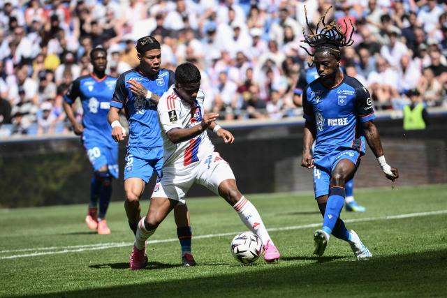 Lyon's Brazilian forward #09 Endrick (C) fights for the ball with Auxerre's Ghanaian defender #14 Gideon Mensah (R) during the French L1 football match between Olympique Lyonnais (OL) and AJ Auxerre at the Groupama Stadium in Decines-Charpieu, central-eastern France, on April 25, 2026. (Photo by ARNAUD FINISTRE / AFP)