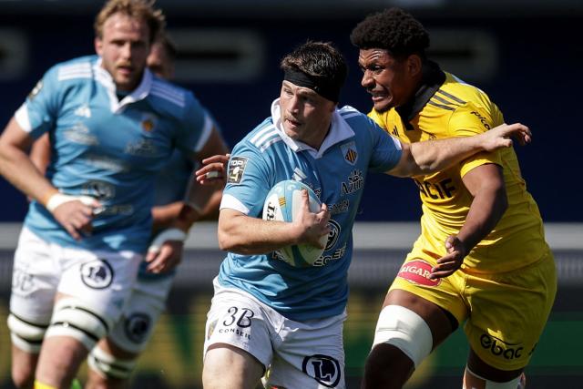 Perpignan's French hooker Victor Montgaillard (C) is tackled during the French Top14 rugby union match between USA Perpignan and Stade Rochelais (La Rochelle) at the Aime-Giral stadium in Perpignan, south-western France on April 25, 2026. (Photo by Valentine CHAPUIS / AFP)