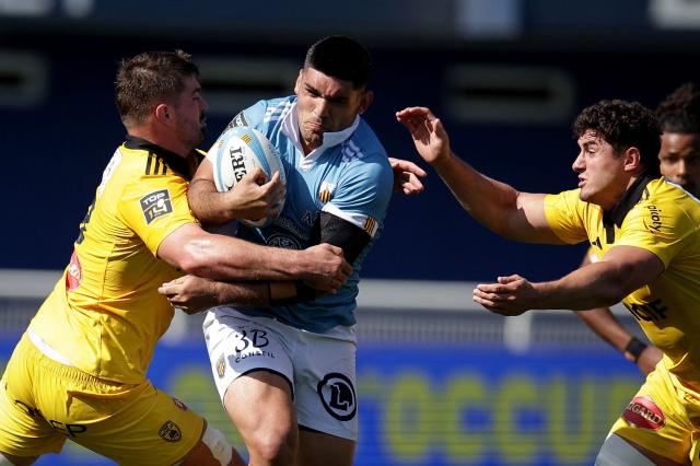 Perpignan's Argentine number eight Joaquin Oviedo (C) is tackled during the French Top14 rugby union match between USA Perpignan and Stade Rochelais (La Rochelle) at the Aime-Giral stadium in Perpignan, south-western France on April 25, 2026. (Photo by Valentine CHAPUIS / AFP)