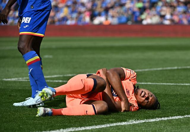 Barcelona's French defender #23 Jules Kounde grimaces in pain on the ground during the Spanish league football match between Getafe CF and FC Barcelona at the Coliseum stadium in Getafe on April 25 , 2026. (Photo by Javier SORIANO / AFP)