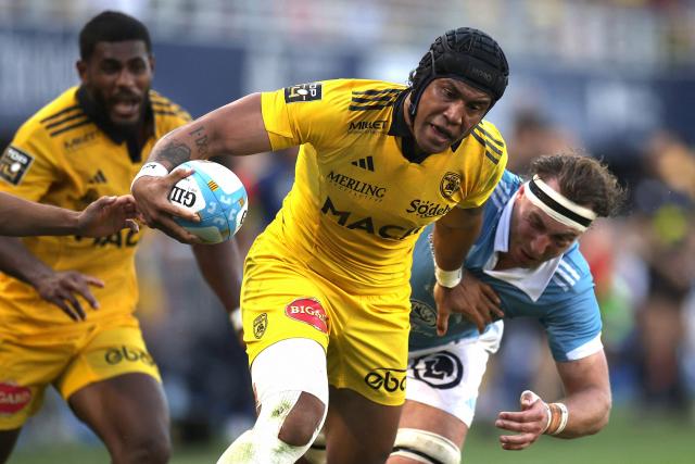 La Rochelle's Australian centre Ulupano Seuteni (C) hands off a tackle during the French Top14 rugby union match between USA Perpignan and Stade Rochelais (La Rochelle) at the Aime-Giral stadium in Perpignan, south-western France on April 25, 2026. (Photo by Valentine CHAPUIS / AFP)