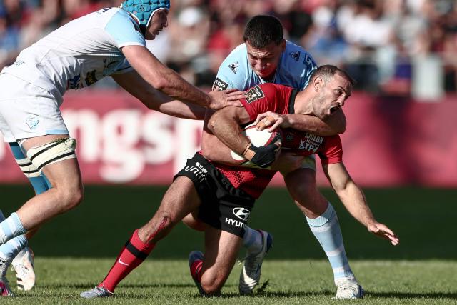 Toulon's French full-back Melvyn Jaminet (C) is tackled by Bayonne's Scottish lock Ewan Johnson (R) during the French Top 14 rugby union match between Rugby Club Toulonnais (Toulon) and Aviron Bayonnais (Bayonne) at Stade Mayol in Toulon, south-eastern France on April 25, 2026. (Photo by Thibaud MORITZ / AFP)