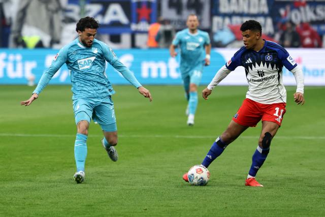 Hamburg's Ghanaian forward #11 Ransford Konigsdorffer (R) and Hoffenheim's Swiss midfielder #07 Leon Avdullahu vie for the ball during the German first division Bundesliga football match between Hamburger SV and TSG 1899 Hoffenheim in Hamburg, northern Germany on April 25, 2026. (Photo by Ibrahim OT / AFP) / DFL REGULATIONS PROHIBIT ANY USE OF PHOTOGRAPHS AS IMAGE SEQUENCES AND/OR QUASI-VIDEO