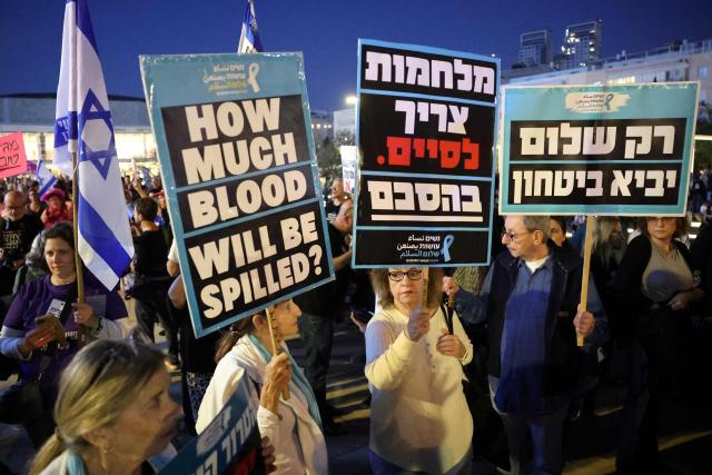 Israeli left-wing activists holding up placards demonstrate in HaBima Square against the ongoing war with Iran and against the Israeli government, in Tel Aviv on April 25, 2026. Since the ceasefire between Israel, the United States, and Iran came into effect, a relative calm has prevailed, with no bombings reported in Iran or the Gulf, after five weeks of conflict that left thousands dead, primarily in Iran and Lebanon. (Photo by Jack GUEZ / AFP) / 
