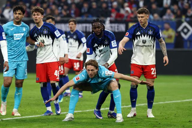 Hoffenheim's Dutch midfielder #18 Wouter Burger (C) stands in front of Hamburg's Nigerian defender #25 Jordan Torunarigha (2R) back as players take their positions during the German first division Bundesliga football match between Hamburger SV and TSG 1899 Hoffenheim in Hamburg, northern Germany on April 25, 2026. (Photo by Ibrahim OT / AFP) / DFL REGULATIONS PROHIBIT ANY USE OF PHOTOGRAPHS AS IMAGE SEQUENCES AND/OR QUASI-VIDEO