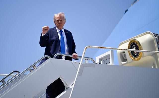 US President Donald Trump pumps his fist as he boards Air Force One at Palm Beach International Airport in West Palm Beach, Florida, on April 25, 2026. President Trump is on his way back to Washington where he will be attending the White House Correspondents' dinner for the first time while in office. (Photo by Kent NISHIMURA / AFP)