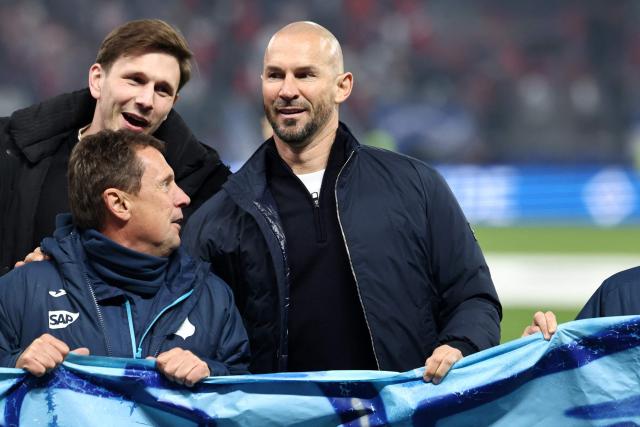 Hoffenheim's Austrian head coach Christian Ilzer (R) celebrates with team members and players after winning the German first division Bundesliga football match between Hamburger SV and TSG 1899 Hoffenheim in Hamburg, northern Germany on April 25, 2026. Hoffenheim won the match 2-1. (Photo by Ibrahim OT / AFP) / DFL REGULATIONS PROHIBIT ANY USE OF PHOTOGRAPHS AS IMAGE SEQUENCES AND/OR QUASI-VIDEO