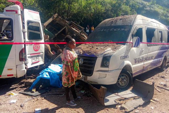 A woman stands next to vehicles destroyed by a bomb attack at El Tunel, on the Popayan-Cali road, in Cajibio, Cauca department, Colombia, on April 25, 2026. A bomb attack on April 25 left seven people dead and 20 injured in an area of Colombia with a strong guerrilla presence, amid a spate of attacks just over a month before the presidential elections, the governor of the Cauca region said. (Photo by Francisco Calderon / AFP)