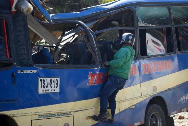 A man observes inside a vehicle destroyed by a bomb attack at El Tunel, on the Popayan-Cali road, in Cajibio, Cauca department, Colombia, on April 25, 2026. A bomb attack on April 25 left seven people dead and 20 injured in an area of Colombia with a strong guerrilla presence, amid a spate of attacks just over a month before the presidential elections, the governor of the Cauca region said. (Photo by Francisco Calderon / AFP)