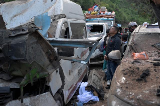 People remain at the site of an explosion after a bomb attack at El Tunel, on the Popayan-Cali road, in Cajibio, Cauca department, Colombia, on April 25, 2026. A bomb attack on April 25 left seven people dead and 20 injured in an area of Colombia with a strong guerrilla presence, amid a spate of attacks just over a month before the presidential elections, the governor of the Cauca region said. (Photo by Joaquin SARMIENTO / AFP)