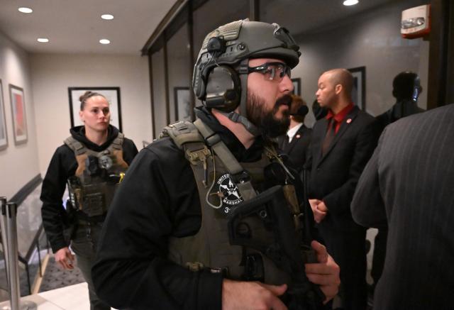 US Marshalls walk through the lobby of the Washington Hilton after shots were heard during the White House Correspondents' Dinner in Washington, DC, on April 25, 2026. Shots were fired as US President Donald Trump attended a press dinner in Washington on April 25 night, witnesses and AFP reporters confirmed. Loud bangs were heard and guests at the black-tie White House Correspondents' Dinner scrambled to hide under tables. Tactical teams with guns drawn took position on the stage where Trump had been sitting before he was evacuated. (Photo by Alex WROBLEWSKI / AFP)