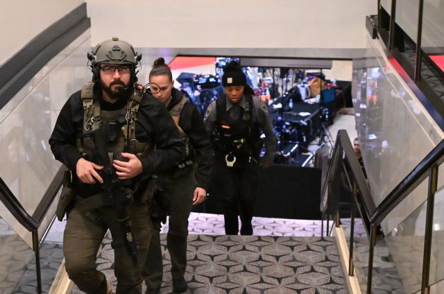 US Marshalls walk through the lobby of the Washington Hilton after shots were heard during the White House Correspondents' Dinner in Washington, DC, on April 25, 2026. Shots were fired as US President Donald Trump attended a press dinner in Washington on April 25 night, witnesses and AFP reporters confirmed. Loud bangs were heard and guests at the black-tie White House Correspondents' Dinner scrambled to hide under tables. Tactical teams with guns drawn took position on the stage where Trump had been sitting before he was evacuated. (Photo by Alex WROBLEWSKI / AFP)