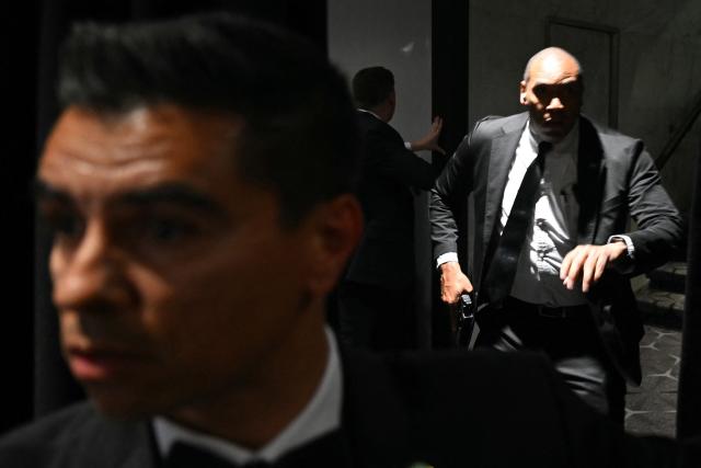 TOPSHOT - Agents draw their guns after loud bangs were heard during the White House Correspondents' dinner at the Washington Hilton in Washington, DC, on April 25, 2026. Shots were fired as US President Donald Trump attended a press dinner in Washington on Saturday night, witnesses and AFP reporters confirmed. Loud bangs were heard and guests at the black-tie White House Correspondents' Dinner scrambled to hide under tables. (Photo by Mandel NGAN / AFP)