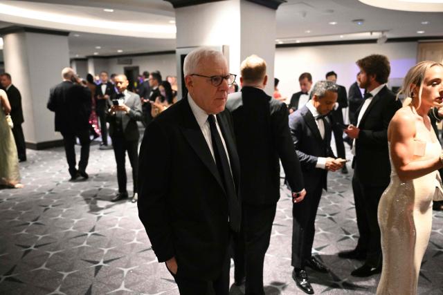 Co-founder of The Carlyle Group David Rubenstein walks back toward the ballroom at the Washington Hilton where shots were heard earlier during the White House Correspondents Dinner in Washington, DC, on April 25, 2026. Shots were fired as US President Donald Trump attended a press dinner in Washington on April 25 night, witnesses and AFP reporters confirmed. Loud bangs were heard and guests at the black-tie White House Correspondents' Dinner scrambled to hide under tables. Tactical teams with guns drawn took position on the stage where Trump had been sitting before he was evacuated. (Photo by Mandel NGAN / AFP)