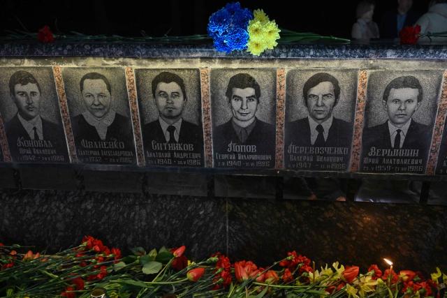This photograph shows flowers and a candle placed in front of a memorial for Chernobyl victims, during a commemoration ceremony marking the 40th anniversary of the explosion at the Chernobyl nuclear power plant, the worst civilian nuclear disaster in history, in the town of Slavutych on April 26, 2026, amid the Russian invasion of Ukraine. (Photo by Genya SAVILOV / AFP)