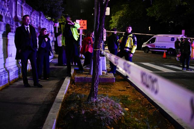 Guests wait outside the Washington Hilton behind police tape after shots were heard during the White House Correspondents' Dinner in Washington, DC, on April 25, 2026. Shots were fired as US President Donald Trump attended a press dinner in Washington on April 25 night, witnesses and AFP reporters confirmed. Loud bangs were heard and guests at the black-tie White House Correspondents' Dinner scrambled to hide under tables. Tactical teams with guns drawn took position on the stage where Trump had been sitting before he was evacuated. (Photo by Kent NISHIMURA / AFP)