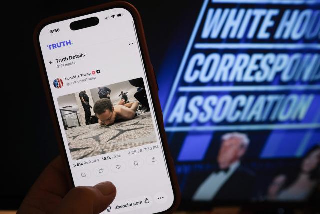 This illustration photo taken in Los Angeles shows a phone with a Truth Social post by US President Donald Trump displaying an image of the alleged suspect in a shooting incident at the White House Correspondents Dinner on the ground after being apprehended on April 25, 2026. US Secret Service agents bundled Donald Trump from the stage as shots rang out Saturday evening at a media gala, in what the president later described as an attack by a "would-be assassin." Armed guards opened fire at the gunman who charged through security screening just outside the ballroom of the hotel, where Trump, First Lady Melania Trump, many senior government officials and hundreds of other black-tie guests had gathered. (Photo by Chris DELMAS / AFP)