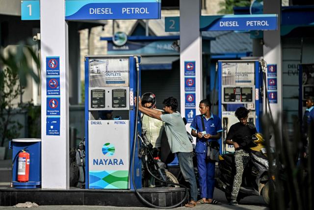 (FILES) Customers refuel their vehicles at a gas station of Nayara Energy Limited, an Indian refiner partly owned by Russia's oil major Rosneft, in Bengaluru on December 12, 2025. India has ramped up purchases of Russian oil in April 2026 and revived alternate supplies from Africa, Iran and Venezuela to blunt a sharp crude shortfall from the crisis-ridden Middle East, analysts say. (Photo by Idrees MOHAMMED / AFP)