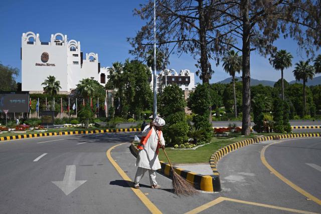 A sanitation worker sweeps a street in front of the Serena Hotel, that hosted the first round of US-Iran peace talks during the Middle East war, after authorities reopened the Red Zone area in Islamabad on April 26, 2026 following eased security measures and restrictions. Pakistan's Prime Minister Shehbaz Sharif said he had spoken to Iranian President Masoud Pezeshkian on April 25 after the second round of US-Iran negotiations in Islamabad were called off and reiterated Islamabad's commitment to facilitating "durable peace". (Photo by Aamir QURESHI / AFP)