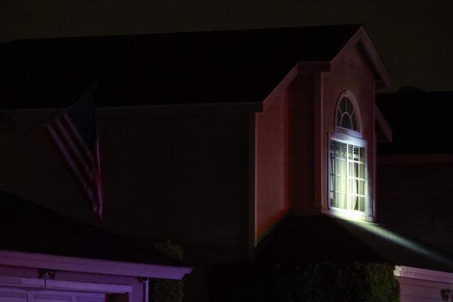A US flag is seen on a neighborhing house as a spotlight is shined on a house associated with the suspected White House Correspondents Dinner shooter as an FBI tactical team arrives in armored vehicles in Torrance, California, on April 25, 2026. US President Donald Trump said April 25 he would give a press conference from the White House press briefing room, shortly after a shooting incident at a gala dinner in Washington. The press conference is set to take place shortly after 10 p.m. (0200 GMT), Trump wrote on his Truth Social platform, adding: "The First Lady, plus the Vice President, and all Cabinet members, are in perfect condition." (Photo by Patrick T. Fallon / AFP)