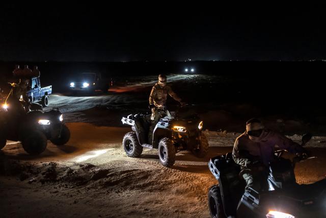 Members of the Mauritanian Coast Guard (GCM) ride on all-terrain vehicles (ATV) during a night patrol in Nouadhibou, on April 23, 2026. (Photo by PATRICK MEINHARDT / AFP)