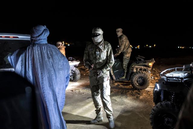 Members of the Mauritanian Coast Guard (GCM) question a man during a night patrol in Nouadhibou, on April 23, 2026. (Photo by PATRICK MEINHARDT / AFP)