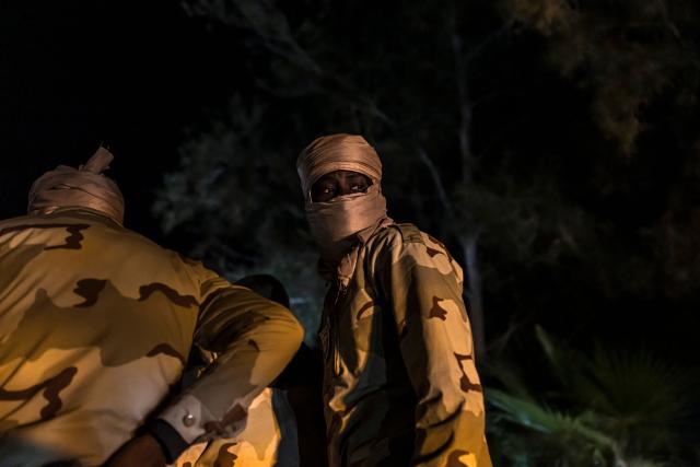 A member of the Mauritanian Coast Guard (GCM) looks back during a night patrol in Nouadhibou, on April 23, 2026. (Photo by PATRICK MEINHARDT / AFP)