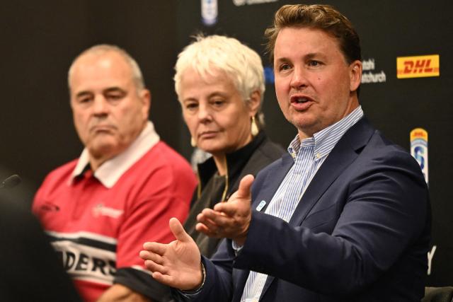 Super Rugby Pacific CEO Jack Mesley (R) speaks to the media as ChristchurchNZ's CEO Ali Adams (C) and Crusaders CEO Colin Mansbridge (L) look on during a press conference at One New Zealand Stadium in Christchurch on April 26, 2026. (Photo by Sanka VIDANAGAMA / AFP)