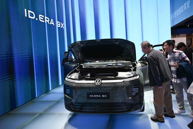 Visitors look at a Volkswagen ID. Era X9 displayed at the Beijing Auto Show in Beijing on April 26, 2026. (Photo by Pedro PARDO / AFP)